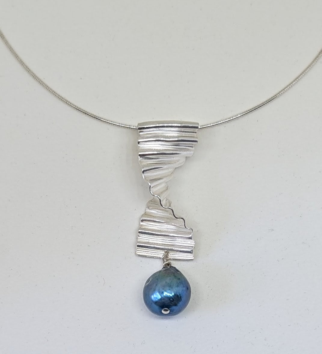 Large silver ripple pendant with large blue pearl