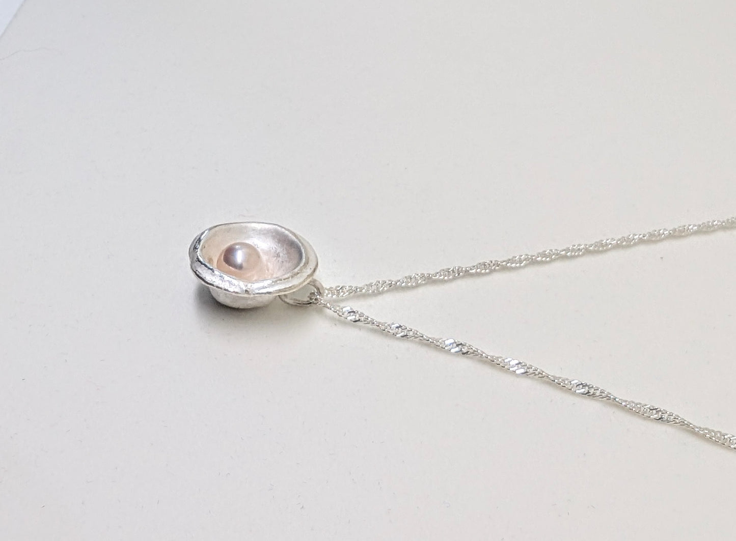 Silver splash pendant with cultured freshwater pearl with delicate hues