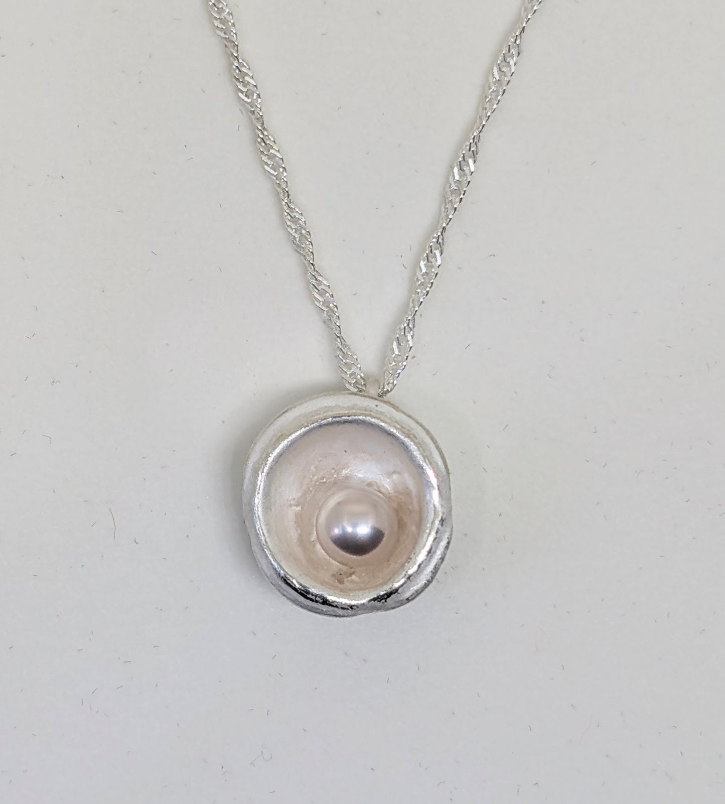 Silver splash pendant with cultured freshwater pearl with delicate hues